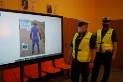 policjanci przy ekranie multimedialnym podczas prelekcji
