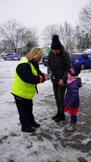 policjantka daje odblaski dziewczunce i jej mamie