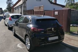 czarny samochód m-ki Renault Clio zaparkowany na ulicy przy posesji blokujący wjazd do bramy