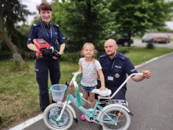policjanci z dzieckiem przy rowerze